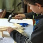 Kind arbeitet mit Holz