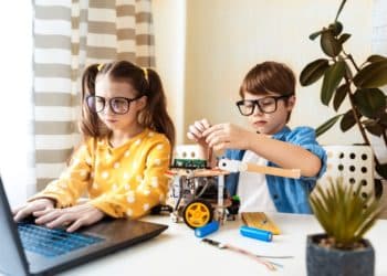 Kinder basteln mit einem Roboter und dem Laptop