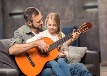 Vater und Tochter spielen Gitarre