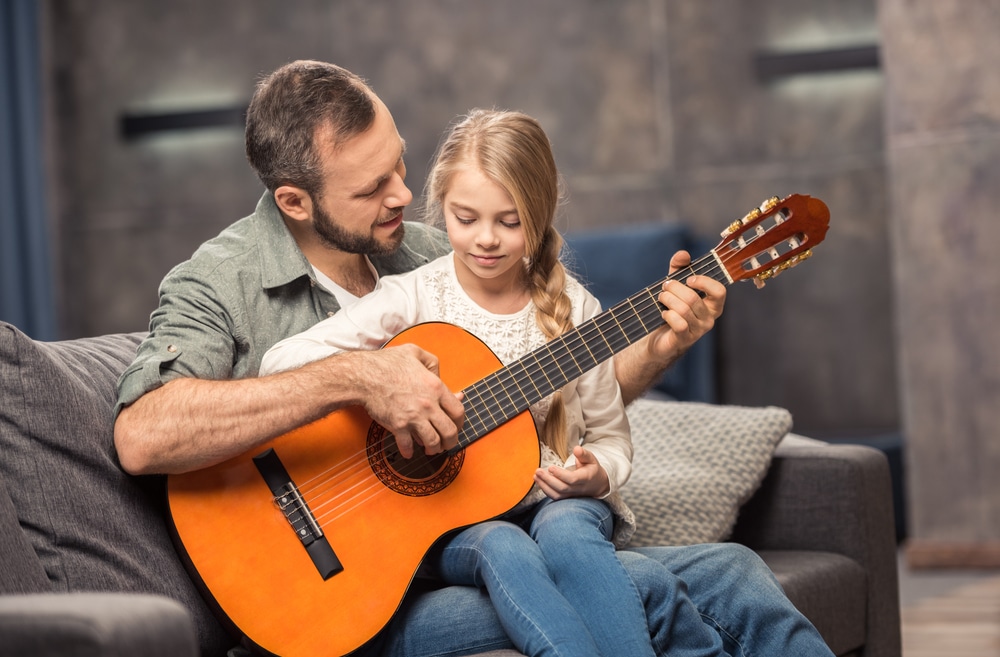 Vater und Tochter spielen Gitarre