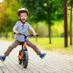 fröhlicher Junge auf einem Balance Bike